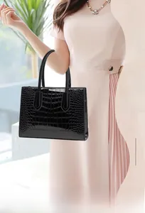 Close-up of black crocodile embossed texture on a high-shine fashion handbag