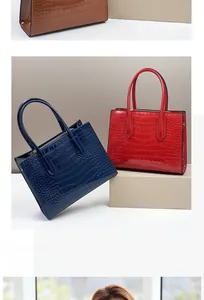 Three elegant crocodile pattern leather handbags in brown navy and red colors