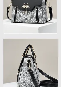 Detail of artistic black and white pattern handbag with flamingo metal clasp and pearls
