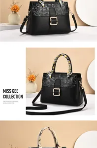 Detail of black faux leather bag with crocodile texture and silk scarf handle decor