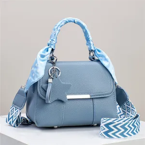 Detail der blauen Lederhandtasche mit Polka-Dot-Schalgriff und Stern-Anhänger