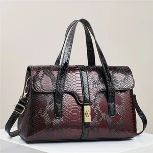 Handtasche mit rot-schwarzer Schlangentextur und goldenem Drehverschluss