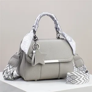 Graue Handtasche aus Leder mit verzierten Seidengriffen und geometrischem Riemen