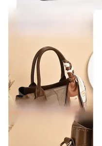 Detail showing the brown patchwork leather handle with decorative fashion print scarf