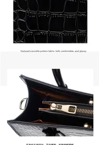 Detail of crocodile embossed leather texture and smooth golden zipper on black tote