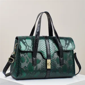 Grüne Handtasche mit Schlangenmuster, goldenem Drehverschluss und Schultergurt