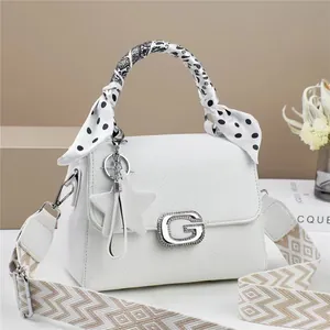 Close-up of white lychee leather handbag featuring G-buckle with rhinestones and silk scarf