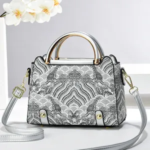 Silver shoulder bag with wave pattern and metallic handle for a minimalist look