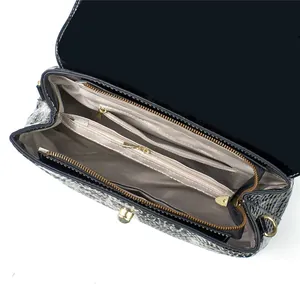 Draufsicht auf die Innenfächer mit beigem Futter und goldfarbenen Hardware-Details