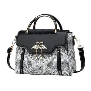 Elegant handbag with embroidery, swan buckle, and pearl charms in classic black and white