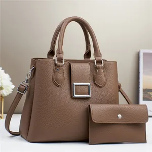 Detail of dark brown lychee textured handbag set with silver buckle and matching wallet