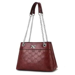 Deep wine red leather crossbody bag with silver bow accent and embossed patterns
