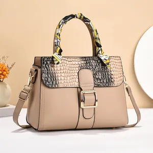 Fashionable beige faux leather handbag with crocodile pattern flap and silk scarf handle