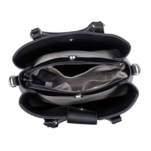 Detail view of the multi-compartment interior and grey lining of the black textured handbag