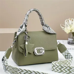 Green leather handbag with G buckle, scarf handle, and geometric patterned strap