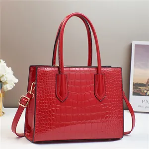 Red crocodile embossed patent leather tote bag with gold hardware and top handles