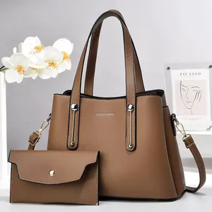 Dettaglio del set borsa tote marrone caramello e pochette con finiture argentate
