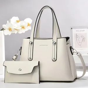 Vista dettagliata della borsa tote e pochette color panna in pelle martellata
