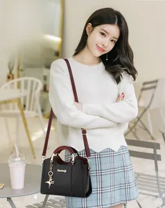 Détail du sac à main bicolore noir et rouge avec pendentif étoile et finitions dorées