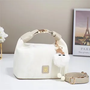 Creamy white cloud handbag with plush charm and adjustable strap for elegant style