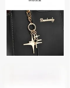 Détail du charm étoile et de la plaque dorée sur le sac à main en cuir noir texturé