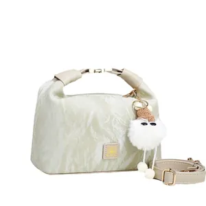 Sage green pleated handbag with plush charm and adjustable shoulder strap for women