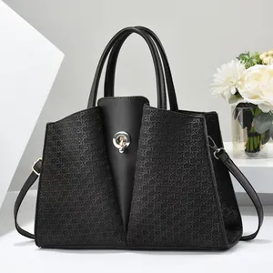 Chic black tote bag with woven texture panels and silver buckle in minimalist setting