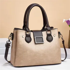 Detail view of champagne gold crossbody bag with brown handles and metallic clasp