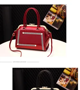 Detail of red patent leather handbag with Greek key pattern and pearl embellishments