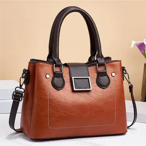 Detail view of the brown leather tote bag with silver hardware and adjustable shoulder strap