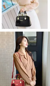 Details der eleganten Muscheltasche mit goldenem Metallrahmen und Lychee-Leder-Textur