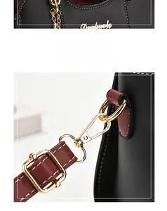Détails du sac à main noir avec garniture dorée et bandoulière en cuir couleur bordeaux