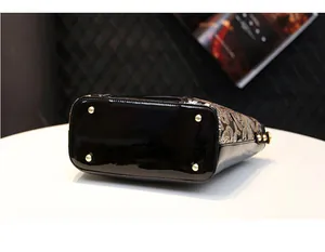 Close-up of elegant black patent leather base with gold-tone metal feet and floral embroidery