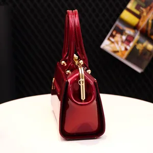 Classic dark red patent leather handbag with vintage metal frame and dual top handles