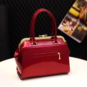 Classic red patent leather handbag with vintage frame closure and metal bow detail