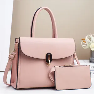 Close-up of pink litchi grain leather tote bag with elegant gold twist lock and accessories