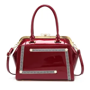 Red patent leather handbag with gold frame, Greek key pattern and pearl accents
