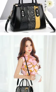Detail of glossy patchwork handbag with crocodile texture and yellow contrast stripe