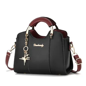 Sac à main noir et bordeaux avec pendentif étoile et surpiqûres contrastées