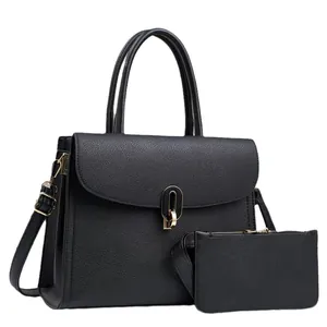 Black pebbled leather tote bag set with golden hardware and matching pouch on white background