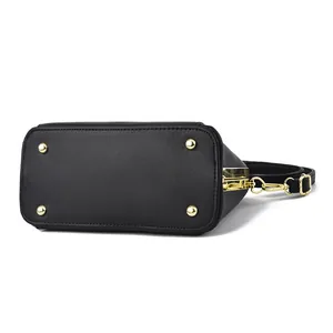 Bodenansicht der schwarzen Ledertasche mit goldenen Schutznieten und Metallbeschlägen