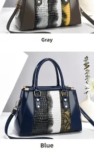 Detail of faux leather patchwork handbag with embossed crocodile texture and gold hardware
