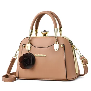 Elegante bolso de mano beige con colgante floral y cierre de gema dorada
