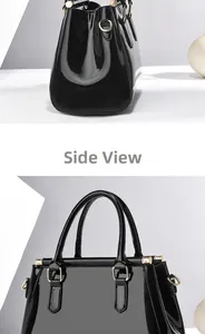 Detail view of glossy black patent leather tote bag with elegant golden metal hardware