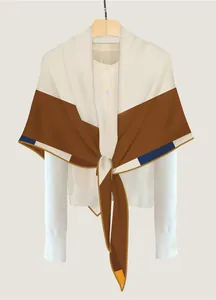 Dettaglio di scialle geometrico effetto seta con motivi color-block beige e caramello