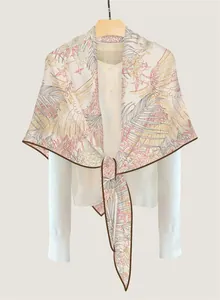Detail of silk-like triangle scarf with tropical leaf pattern knotted over white shirt
