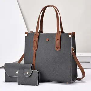 Detailed set of grey denim tote bag with brown leather straps and matching pouches