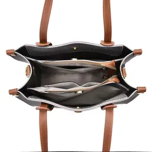 Top view of tote bag interior featuring three compartments and dark brown leather straps