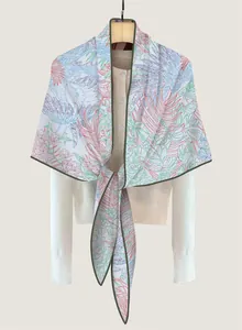 Detail of floral printed triangle shawl with bird motifs and fine green edge stitching