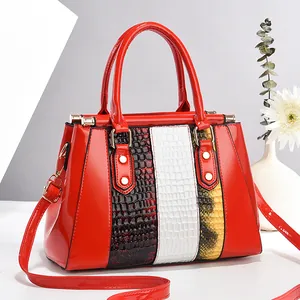 Red glossy patent leather handbag with luxury snake skin patchwork and gold hardware